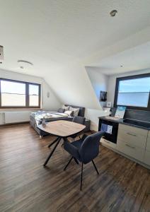 a living room with a table and a bed at Haus Ausreißer 2 - Hafennest in Bensersiel +2 photos