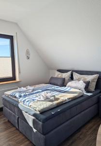 a large blue bed in a room with a window at Haus Ausreißer 2 - Hafennest in Bensersiel