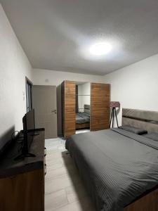 a bedroom with a bed and a desk with a television at Cozy Central Corner in Gjakove