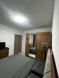 a small bedroom with a bed and a mirror at Cozy Central Corner in Gjakove +3 photos