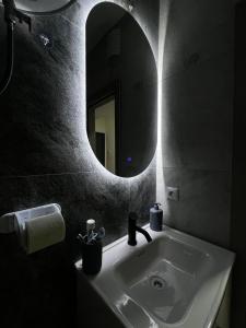 a bathroom with a sink and a mirror at Cozy Central Corner in Gjakove