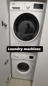 a washer and dryer with a sign that reads laundry machines at Koresh 10 - Emilia suite in Jerusalem