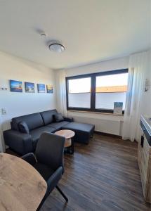 a living room with a couch and a table at Haus Ausreißer 2 - Heimathafen in Bensersiel +2 photos