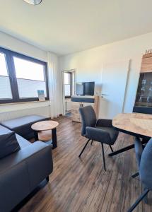 a living room with a couch and a table at Haus Ausreißer 2 - Heimathafen in Bensersiel