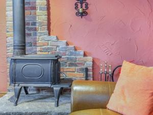 a brick wall with a stove and a couch at Smugglers View Nr Whitby in Ravenscar