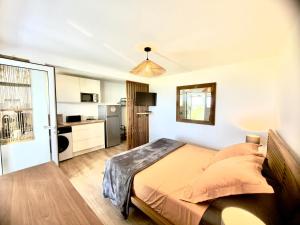 a bedroom with a bed and a kitchen at Sunset View - Panoramic Sea View - Deshaies in Deshaies