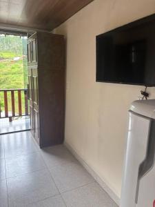 a room with a flat screen tv on the wall at Chalé do Vicente in Ouro Preto