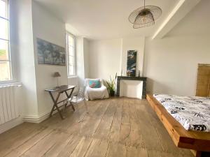 a bedroom with a bed and a desk and a chair at Chambre zen in Châteauneuf-sur-Charente
