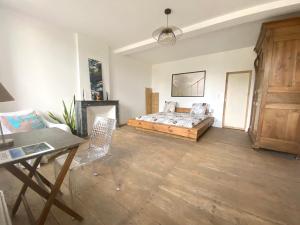 a bedroom with a bed and a desk and a table at Chambre zen in Châteauneuf-sur-Charente