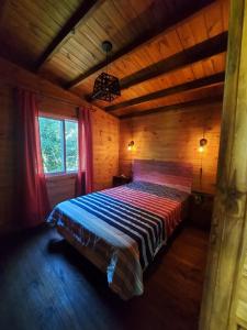 a bedroom with a bed in a wooden cabin at Cabañas Amo Río - Delta in Tigre