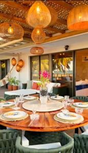 a dining room with a table with glasses and flowers at House Paraíso Flecheiras in Trairi