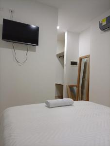 a bedroom with a bed with a flat screen tv on the wall at Adele Hotel in Ríohacha