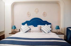 a blue and white bed with blue and white pillows at Nile Transport Hotel in Cairo