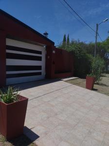 a garage with a white garage door and some plants at Espacio Armonia Junin Balneario in Junín