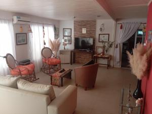 a living room with a couch and chairs and a tv at Espacio Armonia Junin Balneario in Junín