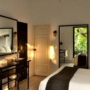 a bedroom with a bed and a desk and a window at Las Casas B&B Boutique Hotel, Spa & Restaurante Cuernavaca in Cuernavaca +86 photos
