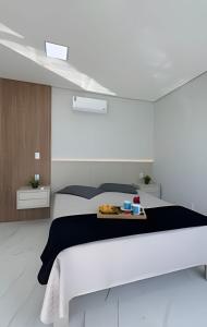 a bedroom with a bed with a tray of food on it at Apto Lavandas|2Qts.Lado Centro Eventos,150m Termas in Piratuba +14 photos