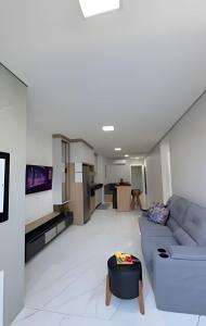a living room with a couch and a tv at Apto Lavandas|2Qts.Lado Centro Eventos,150m Termas in Piratuba