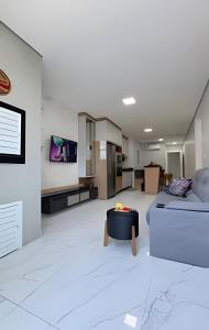 a white living room with a bed and a table at Apto Lavandas|2Qts.Lado Centro Eventos,150m Termas in Piratuba