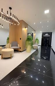 a lobby with a waiting area with a couch and chairs at Apto Lavandas|2Qts.Lado Centro Eventos,150m Termas in Piratuba