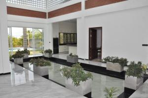 a hallway with potted plants in a building at Northjoy Resort in Kilinochchi