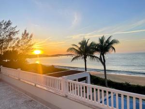 a view of the beach at sunset from a balcony at Casa Praia Parati in Anchieta