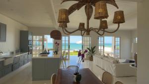 a kitchen and living room with a chandelier at Casa Praia Parati in Anchieta