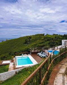 a swimming pool on a deck next to the ocean at Sentinelas do Mar in Arraial do Cabo