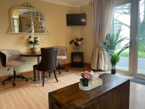 a living room with a table and chairs and a window at Tourmakeady Self Catering in Toormakeady