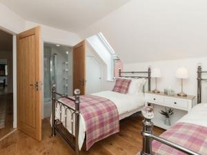 a bedroom with two beds and a walk in shower at Millbank in Ballindalloch