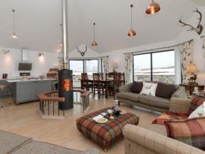 a living room with a couch and a table and a kitchen at Millbank in Ballindalloch