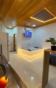 a kitchen with a sink and a tv on the wall at Suíte dos Sonhos-Climatizada,Hidromassagem,Garagem in Piratuba