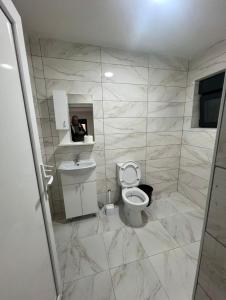 a bathroom with a toilet and a person taking a picture at Guest House Ropojan in Vusanje