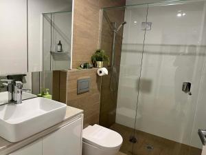a bathroom with a toilet and a sink and a shower at Centrepoint Units Heidelberg in Melbourne +56 photos