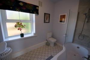 a bathroom with a tub and a toilet and a window at New! Luxury 4 Bedroom Detached House - Central Baslow in Baslow +43 photos