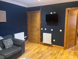 a living room with a couch and a flat screen tv at Cute Cottage Central Bathgate Inc Sofa Bed in Bathgate