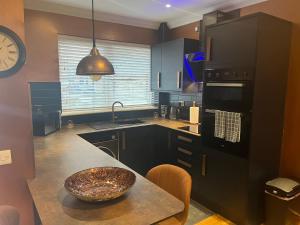 a kitchen with a table and a bowl on the counter at Cute Cottage Central Bathgate Inc Sofa Bed in Bathgate +6 photos