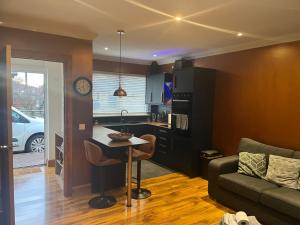 a kitchen and living room with a table and a couch at Cute Cottage Central Bathgate Inc Sofa Bed in Bathgate
