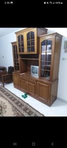 a large wooden cabinet with a microwave in it at one room in Alexandria