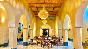 a dining room with a table and chairs and a chandelier at Kasbah Restaurant Citoyenne in Agoudal