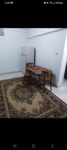 a table and two chairs in a room with a rug at one room in Alexandria