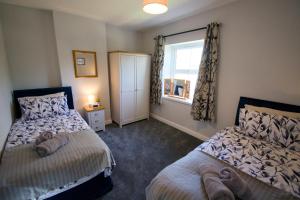 a bedroom with two beds and a window at New! Luxury 4 Bedroom Detached House - Central Baslow in Baslow