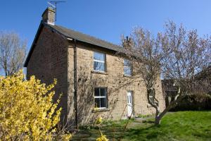 an old brick house with a tree in front of it at New! Luxury 4 Bedroom Detached House - Central Baslow in Baslow