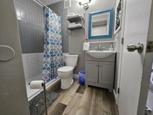 a bathroom with a toilet and a sink and a shower at BEACHSIDE CONDO-WATER AND POOL VIEW Top Floor in Tybee Island +18 photos