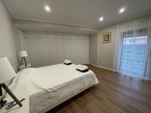 a bedroom with a white bed and a large window at Azorean Sunset Loft 1 in Ribeira Grande