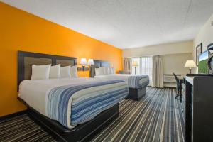 two beds in a hotel room with orange walls at Crossroads Hotel and Huron Event Center in Huron +37 photos