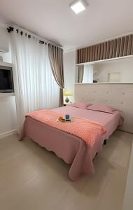 a bedroom with a pink bed in a room at Apto Margaridas|3Q,todo Climatizado,ao lado Termas in Piratuba