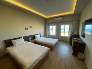 a hotel room with two beds and a television at Al Dora Hotel & Spa in Hurghada +48 photos