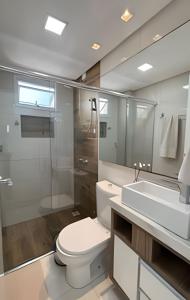 a bathroom with a toilet and a sink and a mirror at Apto Margaridas|3Q,todo Climatizado,ao lado Termas in Piratuba +31 photos