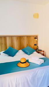 a straw hat sitting on a bed with towels at Zeeva Hotel and Resort in Torre Dei Corsari +107 photos